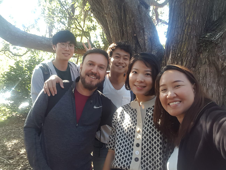 Amigos del curso juntos debajo de un árbol en Languages International